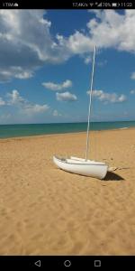 a white boat sitting on a sandy beach at Villa Sunshine in Triscina