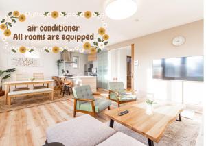 Apartment mit einem Wohnzimmer mit einem Tisch und Stühlen. in der Unterkunft GUEST HOUSE EARTH【THE MOON & THE SUN】 in Sapporo