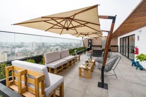 a patio with chairs and an umbrella on a roof at Barranco inolvidable BR1 in Lima