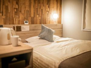 a bedroom with a bed with a pillow on it at Super Hotel Premier Namba Shinsaibashi Natural Hot Spring in Osaka