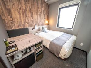 um pequeno quarto com uma cama e uma secretária em Super Hotel Premier Namba Shinsaibashi Natural Hot Spring em Osaka