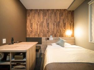 ein Schlafzimmer mit einem Bett und einem Schreibtisch. in der Unterkunft Super Hotel Premier Namba Shinsaibashi Natural Hot Spring in Osaka