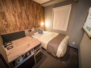 Kleines Zimmer mit einem Bett und einem Schreibtisch. in der Unterkunft Super Hotel Premier Namba Shinsaibashi Natural Hot Spring in Osaka
