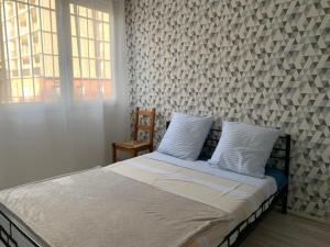 a bed with white sheets and pillows in a bedroom at Duplex Centre Ville 3 chambres in Alès