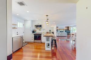 una cucina con armadietti bianchi e pavimenti in legno massello di Big Birch a Gray