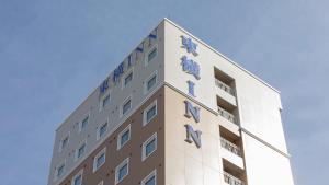 a building with the sign for the hotel at Toyoko Inn Oyama-eki Higashi-guchi No.2 in Oyama