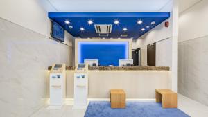 a lobby with a blue ceiling and a counter withools at Toyoko Inn Oyama-eki Higashi-guchi No.2 in Oyama