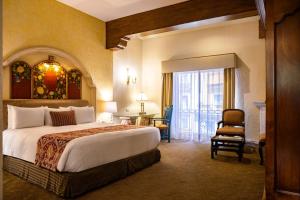 Quinta Real Zacatecas في زاكاتيكاس: غرفة فندقية بسرير كبير وكرسي