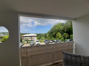 un balcon avec des voitures garées dans un parking dans l'établissement COCON A JOJO, à Le Robert