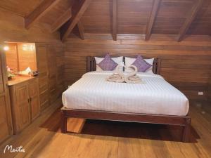ein Schlafzimmer mit einem Bett mit zwei Schwänen darauf in der Unterkunft Lantana House in Ban Pa Muang