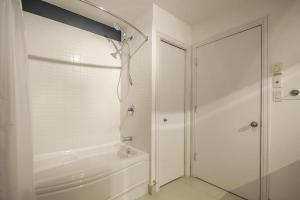 a white bathroom with a tub and a shower at Détente Orford 111 condo/chalet in Orford +20 photos