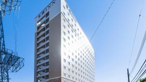 a tall white building in front of a blue sky at Toyoko Inn Kita-toda-eki Higashi-guchi in Toda