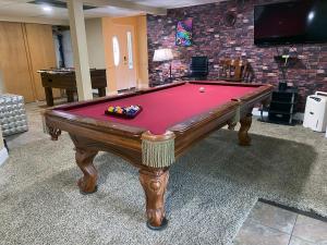 una mesa de billar con una cubierta roja en una habitación en WOW!! Ultimate Pocono Retreat, Hot Tub, Game Room, Deck, Lakes, Skiing, Pools en Long Pond