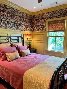 a bedroom with a large bed with a red blanket at New Construction Cottage in Downtown Savannah Arts District in Savannah
