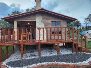 a small log cabin with a deck at cabaña el rio 2 in Zacatlán
