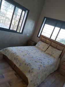 um quarto com uma cama grande e 2 janelas em Residance Perla Bouznika em Bouznika
