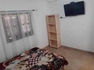 a bedroom with a bed and a flat screen tv at La Termenia in Termas de Río Hondo