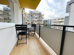 un balcón con 2 sillas y una mesa. en YamaLuxe Apartments - WestSide 2, en Floreşti