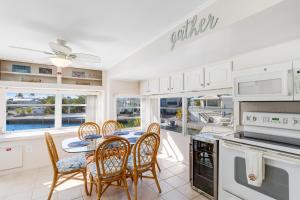 a dining room with a table and chairs and a kitchen at Dock Holiday in Cudjoe Key