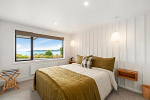ein Schlafzimmer mit einem Bett und einem großen Fenster in der Unterkunft Lake Terrace Lodge - Luxury Taupo Accommodation in Taupo