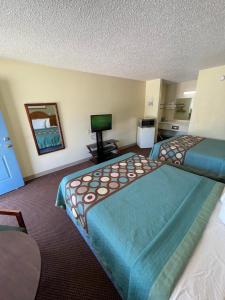 a hotel room with two beds and a flat screen tv at Executive Inn in Mountain Home