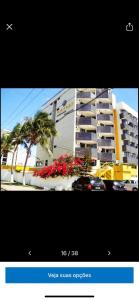 a picture of a building with palm trees and flowers at Hotel Victory flat in Cabedelo