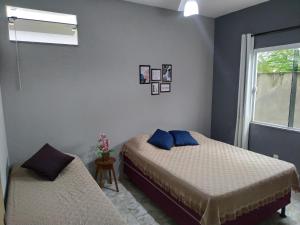 a bedroom with two beds and a window at Flat Solife 2 Cabo Frio-Búzios in Cabo Frio