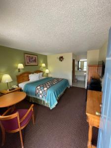 ein Hotelzimmer mit einem Bett und einem Tisch in der Unterkunft Executive Inn in Mountain Home