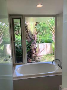 eine Badewanne im Bad mit 2 Fenstern in der Unterkunft 727セブンツーセブン石垣島ベース in Ishigaki-jima