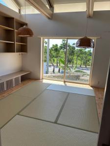 Habitación con ventana grande y alfombra grande. en 727セブンツーセブン石垣島ベース, en Ishigaki Island