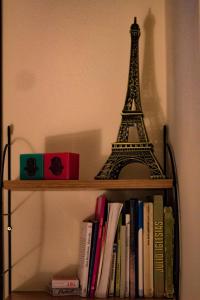 un estante de libros con una estatua de la torre Eiffel en Chambre des palmiers en Rabat