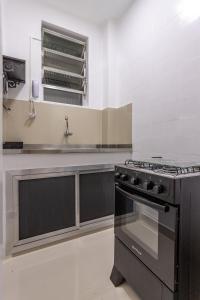 uma cozinha com um fogão e um lavatório em Atlântica Palace Vista Mar no Rio de Janeiro