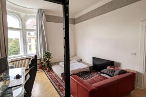 a living room with a red couch and a mirror at Modern meets Classic - near Volkspark Schöneberg in Berlin