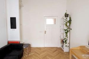 a living room with a black couch and a door at Modern meets Classic - near Volkspark Schöneberg in Berlin