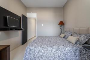 um quarto com uma cama e uma televisão de ecrã plano em Atlântica Palace Vista Mar no Rio de Janeiro