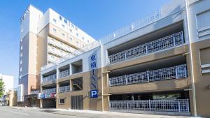 伊势市Toyoko Inn Iseshi Eki的街道上的公寓楼,设有停车场
