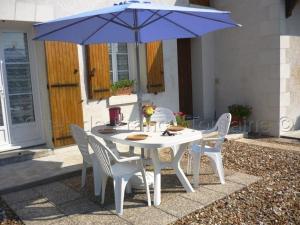 アンボワーズにあるGîte Amboise, 2 pièces, 2 personnes - FR-1-381-55の白いテーブルと椅子(青い傘付)