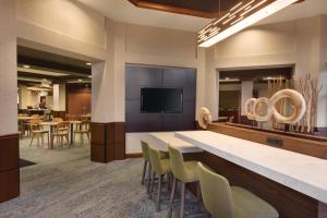 a lobby with a bar with chairs and a television at Courtyard by Marriott Fort Smith Downtown in Fort Smith