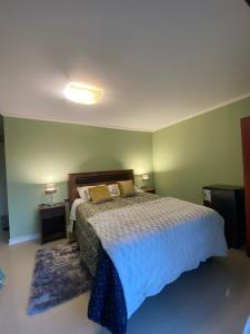 een slaapkamer met een groot bed en 2 nachtkastjes bij Alojamiento Los Nogales in Santa Cruz