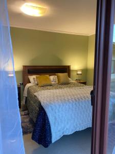 um quarto com uma cama com almofadas amarelas em Alojamiento Los Nogales em Santa Cruz