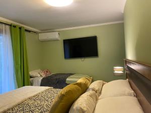 1 dormitorio con 2 camas y TV de pantalla plana en Alojamiento Los Nogales, en Santa Cruz