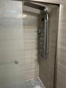 een douche met een glazen deur in de badkamer bij Cozy Inspired Studio Apartment in Newark