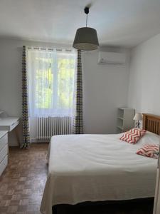a bedroom with a large bed and a window at Superbe Villa Piscine Le Céladore de Sarlat Climatisé, 7 Min à pied du Centre in Sarlat-la-Canéda
