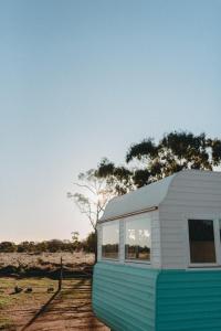 a white and blue house sitting in a field at Meralda Station in Cobar