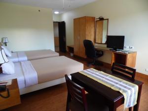 um quarto de hotel com uma cama e uma secretária com um computador em Albergo Hotel em Baguio