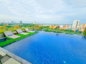 a large swimming pool with lounge chairs on a building at Le Botum Hotel in Phnom Penh