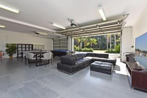 a living room with a couch and a pool table at Lake Palm Resort Luxury Retreat absolute Waterfront on 3 acres at Lake Macquarie. in Dora Creek