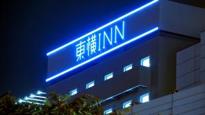 a building with a blue neon sign on it at Toyoko Inn Osaka Namba in Osaka