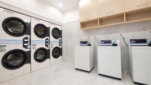 a laundry room with four washing machines and cabinets at Toyoko Inn Osaka Namba in Osaka