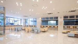 a lobby with a waiting area with tables and chairs at Toyoko Inn Osaka Namba in Osaka